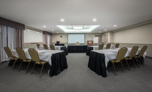 a conference room with tables and chairs and a screen at Chateau Bedford Trademark Collection by Wyndham in Halifax