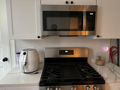 a kitchen with a stove top oven and a microwave at HomeStay in Boston - Dorchester Fields Corner Area in Boston