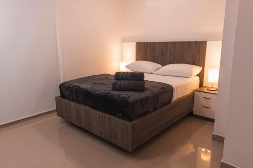 a bedroom with a bed with a wooden head board at Hotel Boutique Business Center in Cali