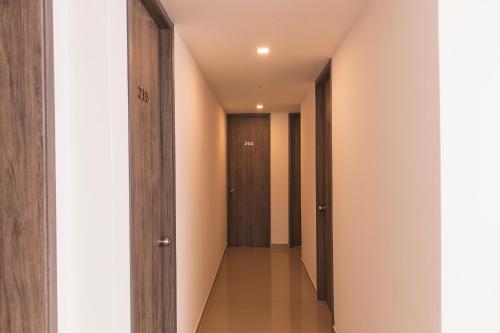a hallway with wooden doors and a long corridor at Hotel Boutique Business Center in Cali