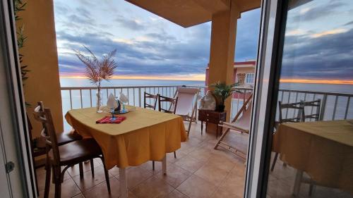 a table on a balcony with a view of the ocean at arena y mar in Tavernes de Valldigna
