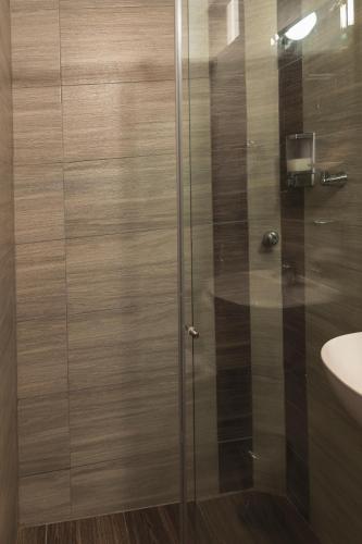 a shower with a glass door next to a sink at Hotel Boutique Business Center in Cali