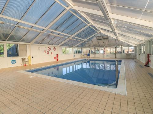 a large indoor swimming pool in a building at Rookley Lake Cottage in Ventnor