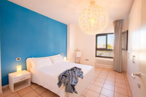 a blue bedroom with a white bed and a chandelier at Casa Adelaide in Senigallia