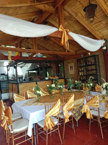 a dining room with a table and chairs with yellow bows at Arte sin Fronteras Hostel in Paipa