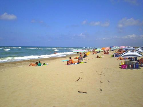 a group of people sitting on a beach with umbrellas at Tuscany - Romantic Getaway in Montecatini Val di Cecina