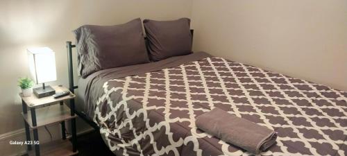 a bedroom with a bed with a brown and white comforter at HomeStay in Boston - Dorchester Fields Corner Area in Boston