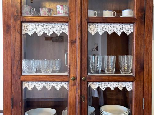 a wooden cabinet with glasses in it at Niriides Studios & Apartments in Kithnos