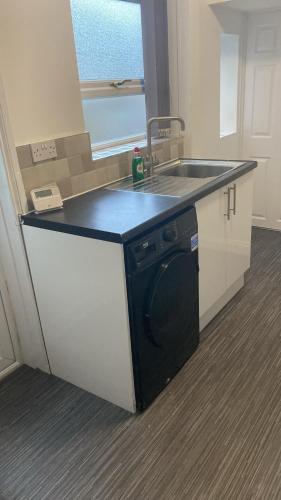a kitchen with a sink and a dishwasher at Happy Homes in Stoke on Trent