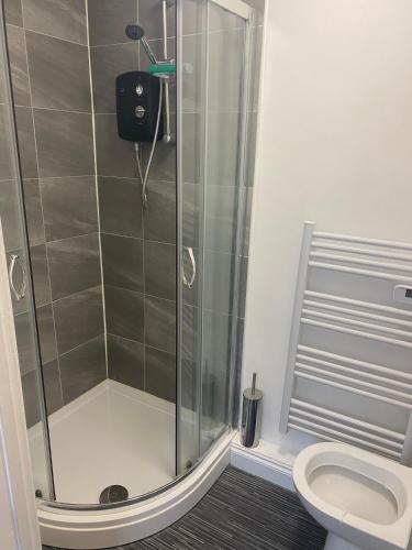 a shower stall in a bathroom with a toilet at Happy Homes in Stoke on Trent