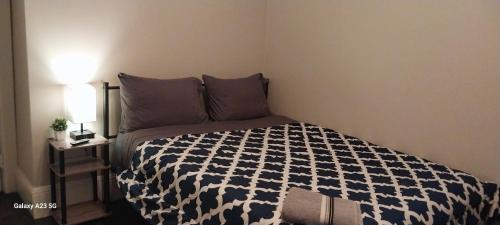 a bedroom with a bed with a black and white comforter at HomeStay in Boston - Dorchester Fields Corner Area in Boston