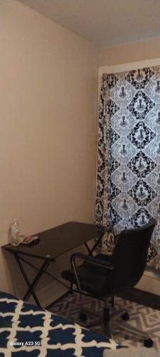 a chair and a table in a room with a curtain at HomeStay in Boston - Dorchester Fields Corner Area in Boston