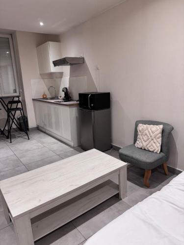 une cuisine avec une table, une chaise, une table et un canapé dans l'établissement Studio en centre ville, à Montceau-les-Mines