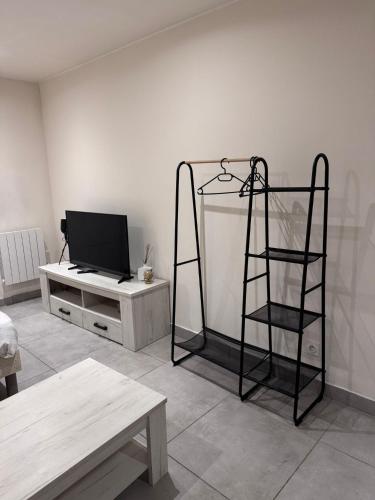 - un salon avec une télévision et une étagère dans l'établissement Studio en centre ville, à Montceau-les-Mines