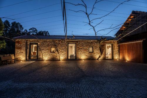a brick house with lights in front of it at Refúgio com jardim perto do Porto in Porto