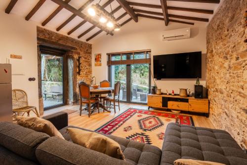 a living room with a couch and a tv at Refúgio com jardim perto do Porto in Porto
