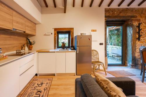 a kitchen and living room with a refrigerator at Refúgio com jardim perto do Porto in Porto