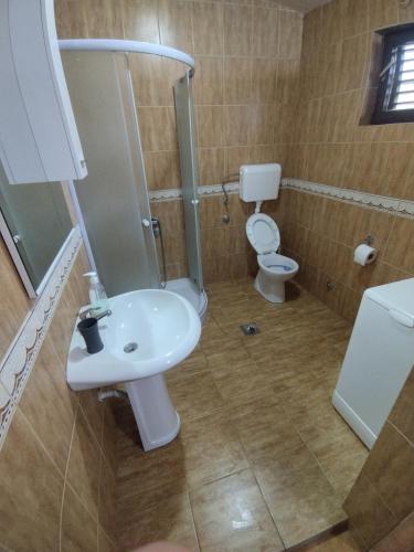 a bathroom with a white sink and a toilet at Forest Home in Golubovci