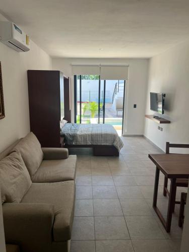 a living room with a couch and a bed at Apartamentos Marea CLOSE TO THE AIRPORT in Cancún