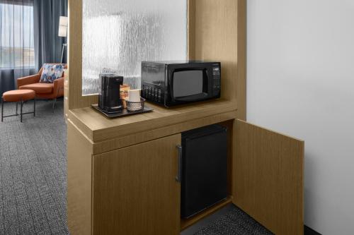 a hotel room with a television and a microwave at Courtyard by Marriott Orlando South/Grande Lakes Area in Orlando