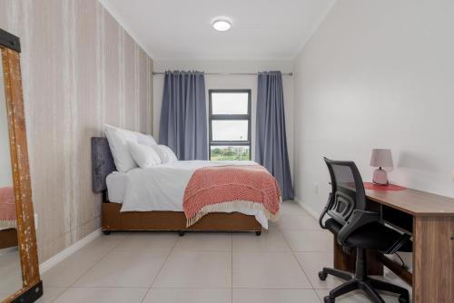 a bedroom with a bed and a desk at Fredas Place 92 On New in Midrand