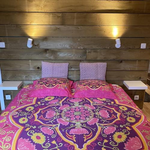 a bed with a purple blanket and pillows at Ferme de Filot 3 in Hamoir