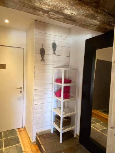 a white shelf in a room with red pillows at Ferme de Filot 3 in Hamoir
