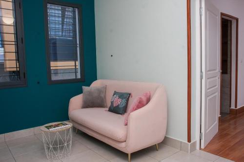 a pink chair with two pillows sitting in a room at HappyNice guesthouse in Andoharanofotsy