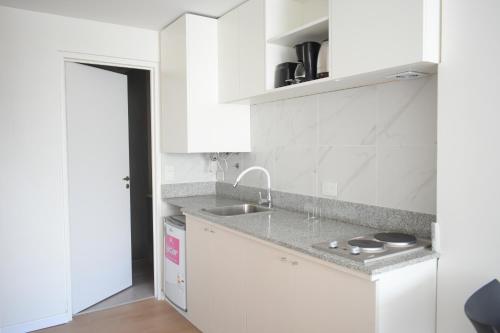 a kitchen with white cabinets and a sink at Torrar Suites in Buenos Aires