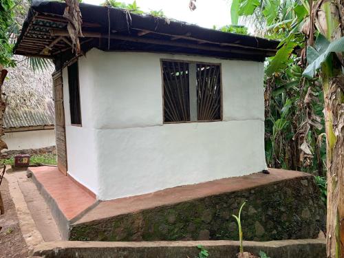 a small white building with a window on top at El Zopilote in Balgue
