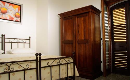 a bedroom with a bed and a wooden door at Salento Terra Maris in Cocumola