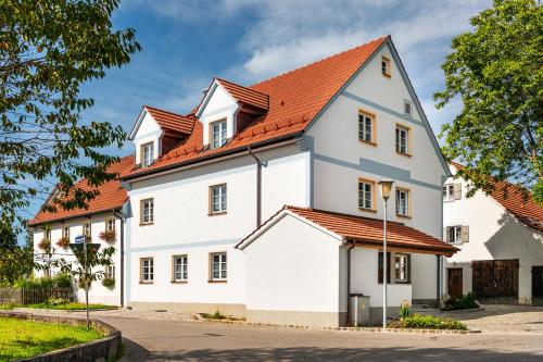ein weißes Haus mit orangefarbenem Dach in der Unterkunft Gästehaus Neubauer in Hörbach