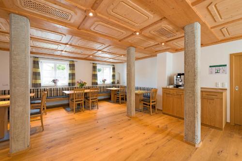 a large room with columns and tables and chairs at Gästehaus Neubauer in Hörbach