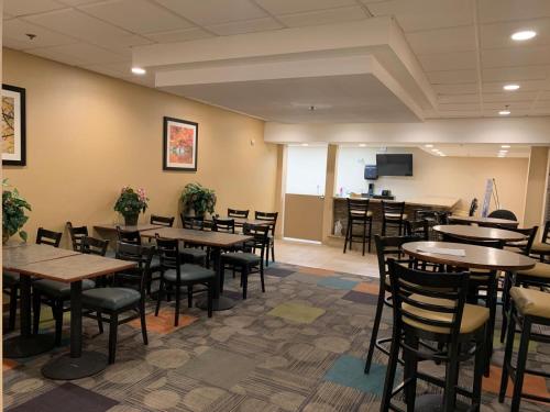 a restaurant with tables and chairs in a room at Clarion Inn I-94 near Expo Center in Kalamazoo