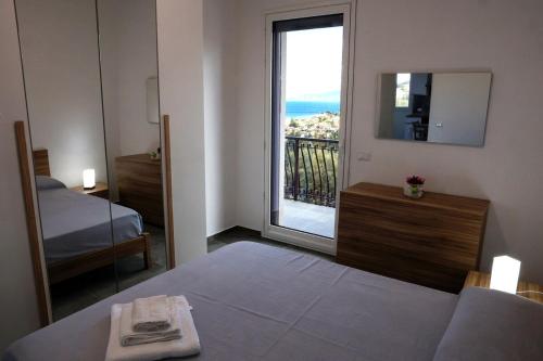 Un dormitorio con una cama y una ventana con vistas. en Trabia Casa Bianca B, en Mandra Capreria