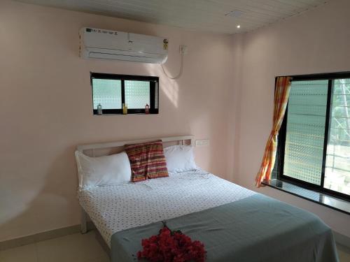un dormitorio con una cama y una ventana en Alibaug Homestay by Weekend Thrills, en Alibaug