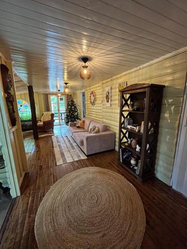 a living room with a couch and a book shelf at Sítio com piscina, churrasqueira, lareira, fogão à lenha, mesa de sinuca e vista para as montanhas in Santo Amaro da Imperatriz