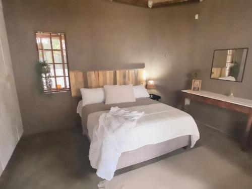 Un dormitorio con una gran cama blanca y una ventana. en Lilibet, en Rustenburg