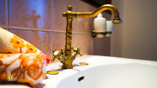 a bathroom sink with a gold faucet at Villa Gambula - Relax and Pool in Perdaxius