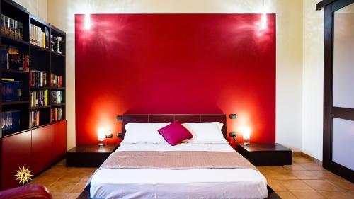 a bedroom with a red wall and a bed at Villa Gambula - Relax and Pool in Perdaxius