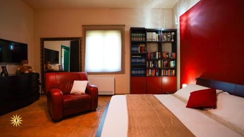a bedroom with a bed and a chair and a mirror at Villa Gambula - Relax and Pool in Perdaxius