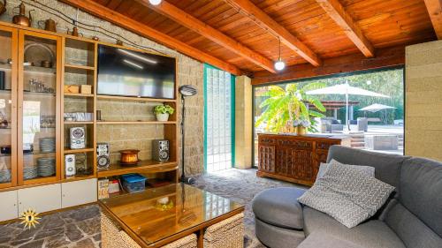 a living room with a couch and a television at Villa Gambula - Relax and Pool in Perdaxius