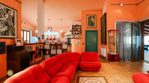 a living room with a red couch and red chairs at Villa Gambula - Relax and Pool in Perdaxius