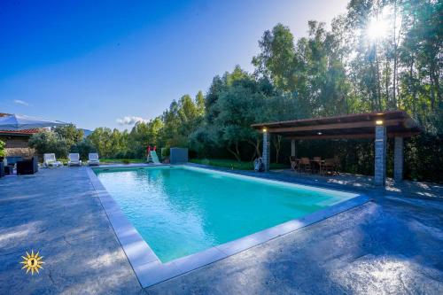 a swimming pool in a backyard with a pergola at Villa Gambula - Relax and Pool in Perdaxius
