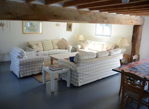 un salon avec deux canapés et une table dans l'établissement The Coach House, à Saint-Aubin-de-Bonneval