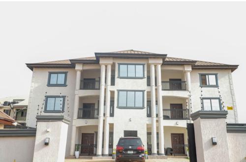 a car parked in front of a large building at Luxecom Apartments in Ashalebotwe