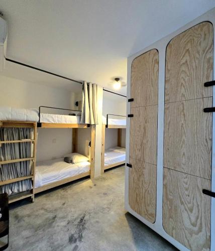 a room with two bunk beds and a closet at HOM Hostel Boutique in Playa del Carmen
