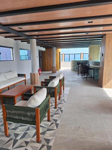 a lobby with benches and a table and a piano at Hotel Brasil Tropical in Fortaleza