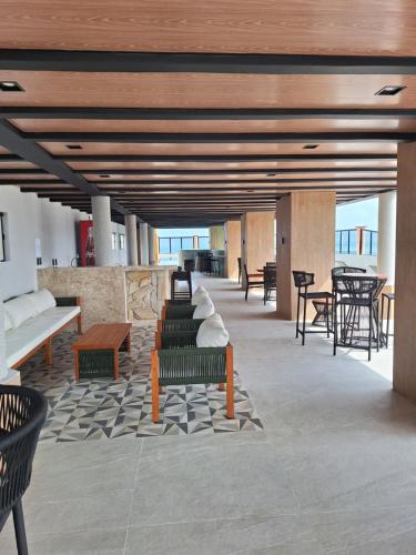 a lobby with benches and tables in a building at Hotel Brasil Tropical in Fortaleza