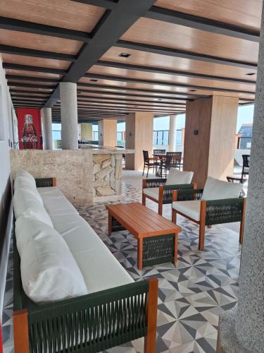 a lobby with benches and a table and chairs at Hotel Brasil Tropical in Fortaleza